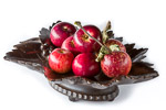 Black Forest Musical Fruit Bowl with Swiss musical movement, shown as centrepiece and deeply filled with deep red shiny apples